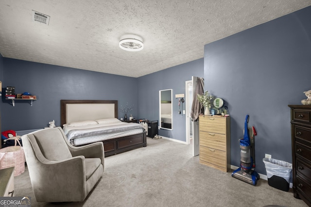 bedroom featuring light colored carpet and a textured ceiling