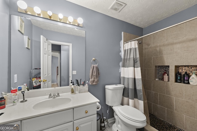 bathroom featuring toilet, a textured ceiling, walk in shower, and vanity