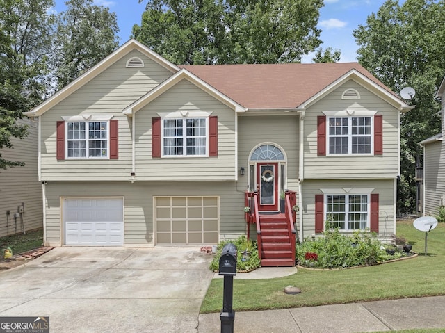 split foyer home featuring a garage and a front yard