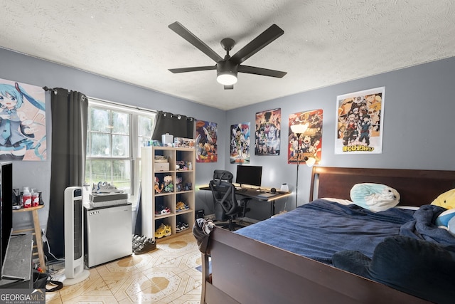 bedroom featuring ceiling fan, refrigerator, and a textured ceiling