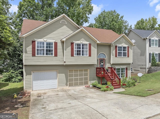 raised ranch with a garage and a front lawn