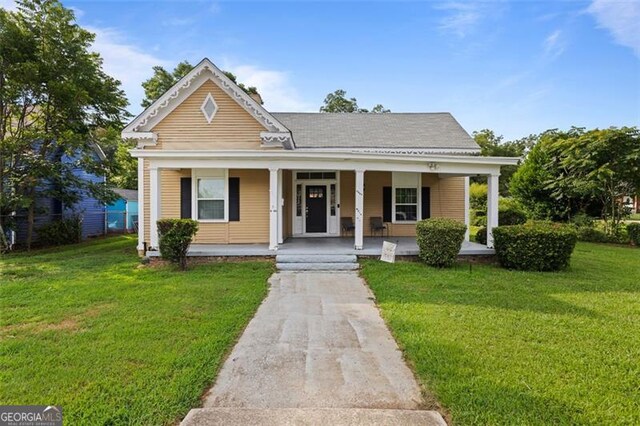 bungalow featuring covered porch and a front yard