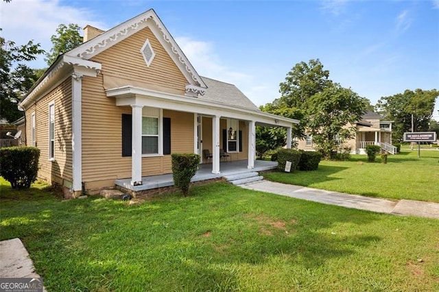 view of front of home with covered porch and a front lawn