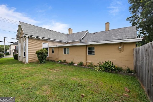 back of house with a lawn