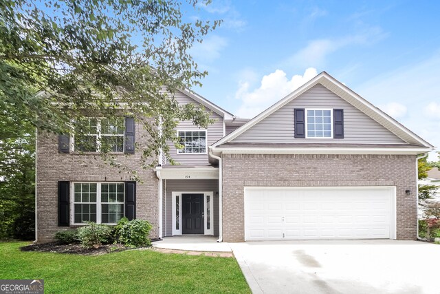 view of front of house featuring a garage and a front lawn