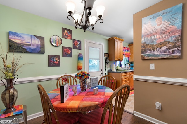 dining room with hardwood / wood-style flooring, sink, and a chandelier