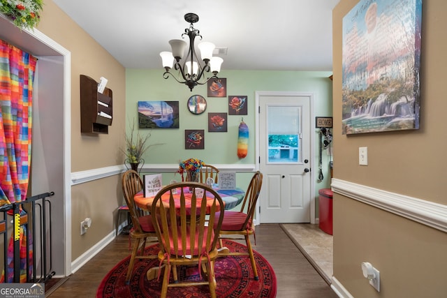 dining space with hardwood / wood-style flooring and a notable chandelier