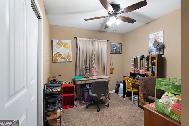 carpeted office with visible vents, baseboards, and a ceiling fan