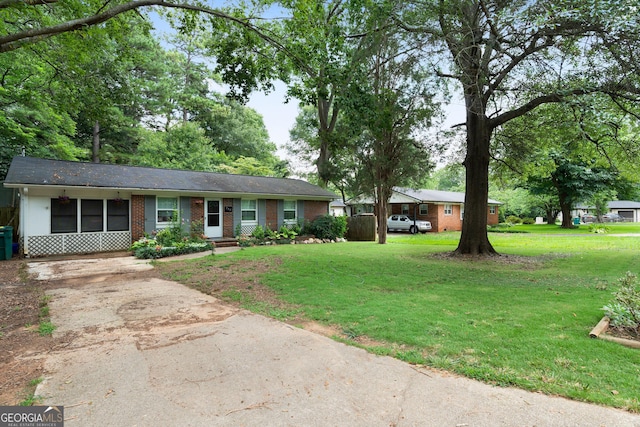 ranch-style home with concrete driveway, a front yard, and brick siding