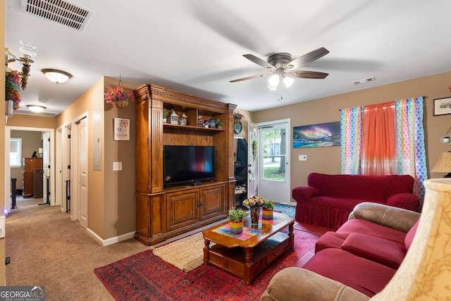 carpeted living area featuring visible vents, ceiling fan, and baseboards