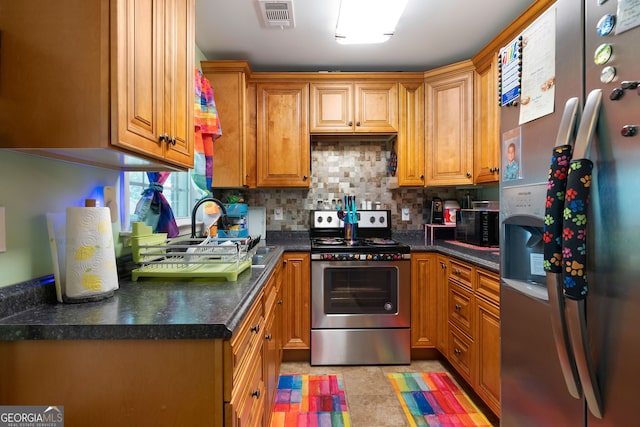 kitchen featuring decorative backsplash, sink, appliances with stainless steel finishes, and light tile patterned floors