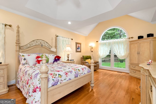 bedroom featuring crown molding, light hardwood / wood-style flooring, and lofted ceiling