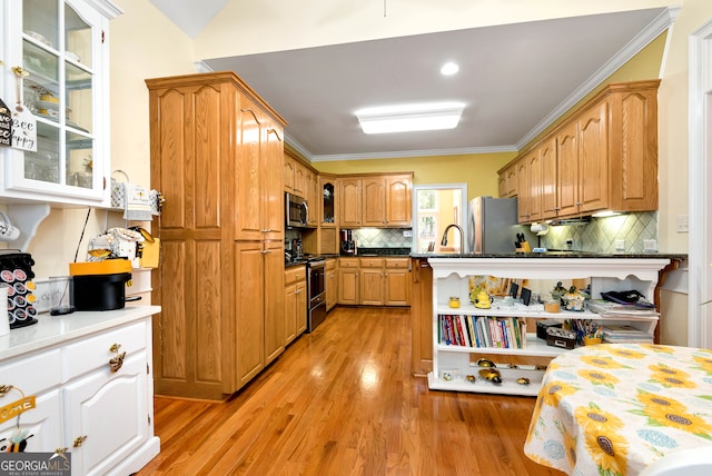 kitchen with appliances with stainless steel finishes, light hardwood / wood-style flooring, tasteful backsplash, and ornamental molding