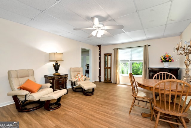 dining area featuring light hardwood / wood-style floors, a drop ceiling, and ceiling fan