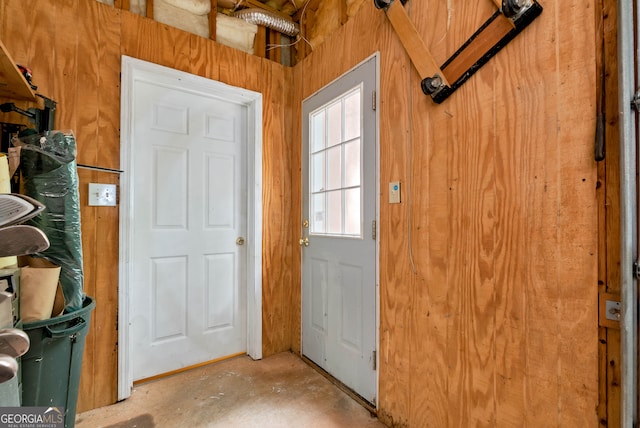 doorway to outside with wooden walls