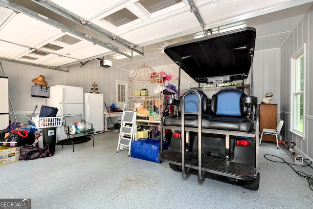 garage with a garage door opener and white refrigerator