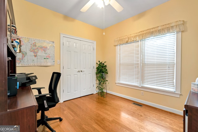 office space featuring a wealth of natural light, ceiling fan, and light wood-type flooring