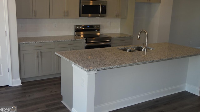 kitchen with light stone counters, sink, dark hardwood / wood-style flooring, and stainless steel appliances