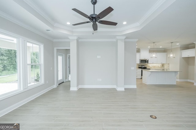 unfurnished living room with plenty of natural light, crown molding, and sink