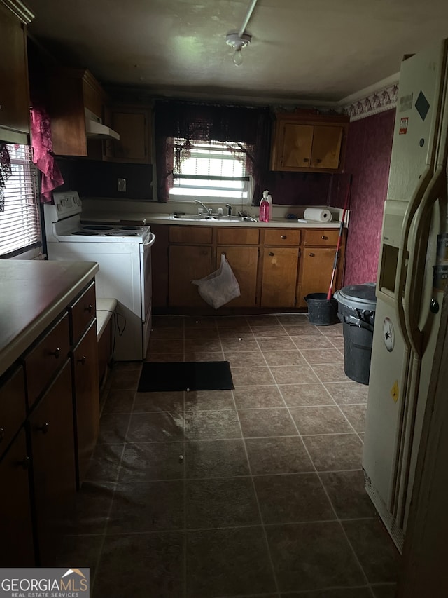 kitchen with plenty of natural light, wall chimney exhaust hood, white appliances, and tile patterned floors