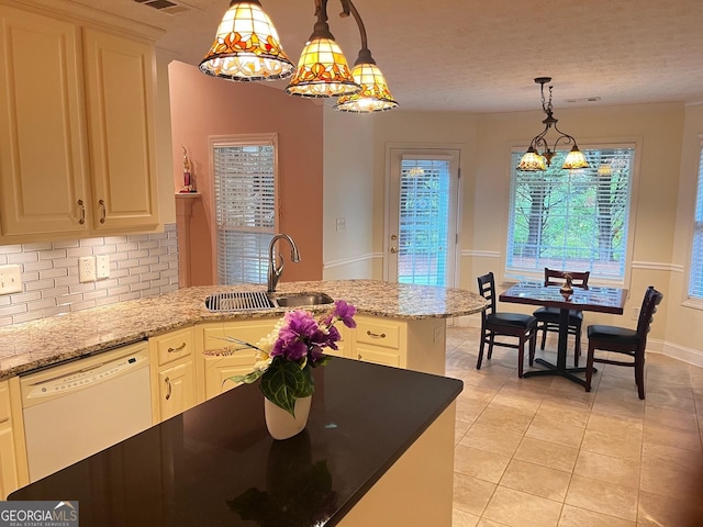 kitchen featuring sink, light stone counters, decorative light fixtures, dishwasher, and backsplash