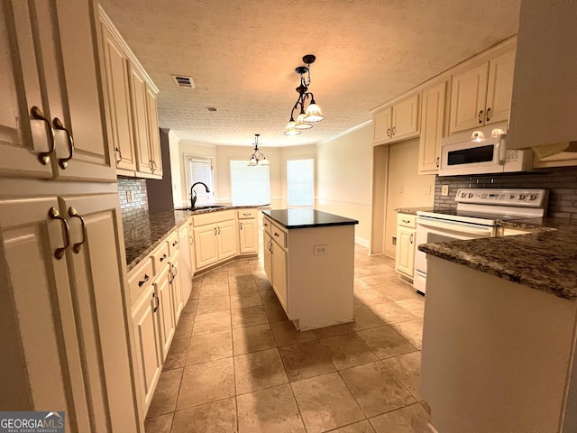 kitchen with a kitchen island, decorative light fixtures, tasteful backsplash, sink, and white appliances