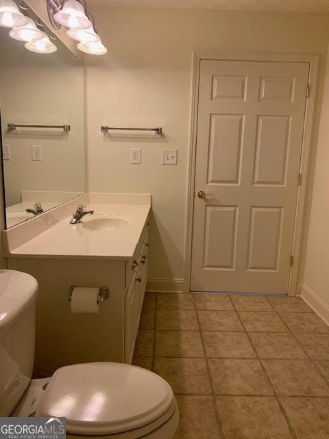 bathroom featuring vanity, tile patterned flooring, and toilet