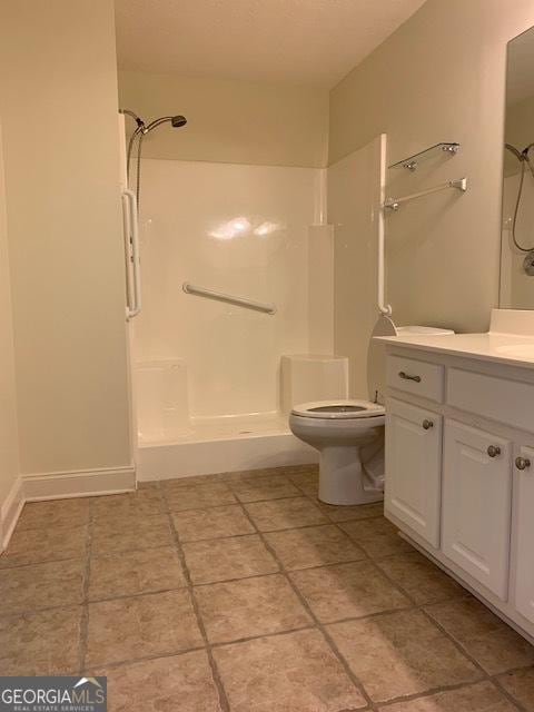 bathroom with walk in shower, vanity, and toilet