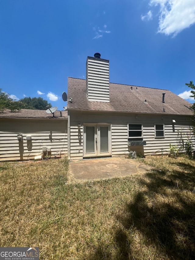 back of property with a yard, a patio area, and french doors