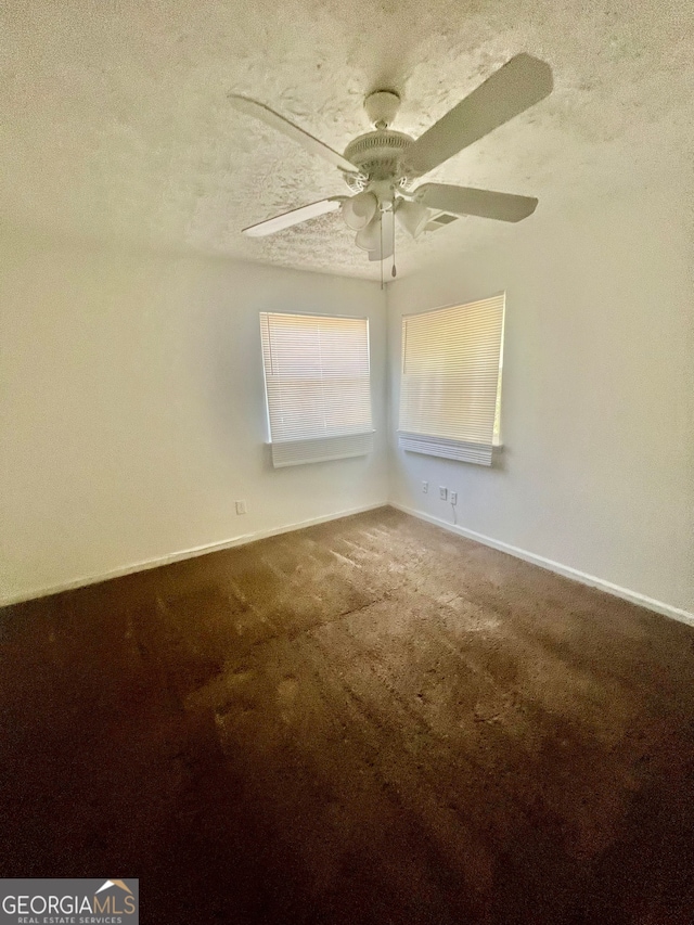 carpeted empty room featuring ceiling fan and a textured ceiling