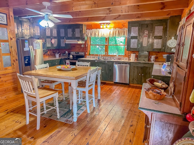 kitchen featuring light wood-type flooring, ceiling fan, stainless steel appliances, beamed ceiling, and sink