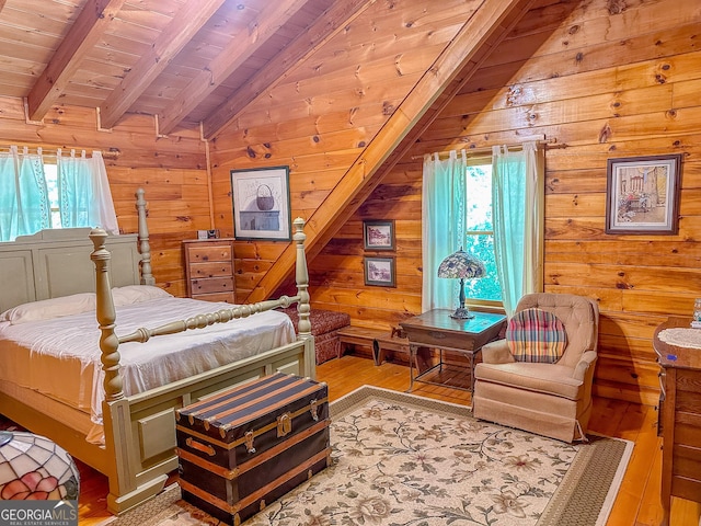 bedroom featuring lofted ceiling with beams, wooden walls, light wood-style floors, and wooden ceiling