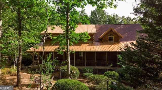 rear view of house featuring a sunroom and log exterior