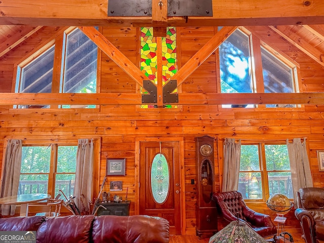 living room with high vaulted ceiling and wood walls