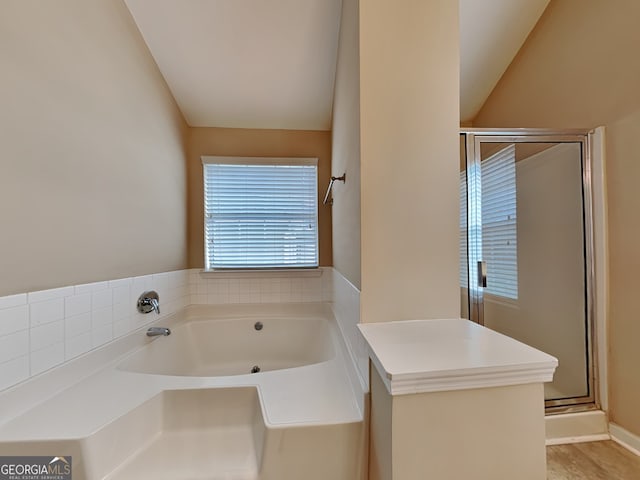 bathroom with walk in shower and vaulted ceiling