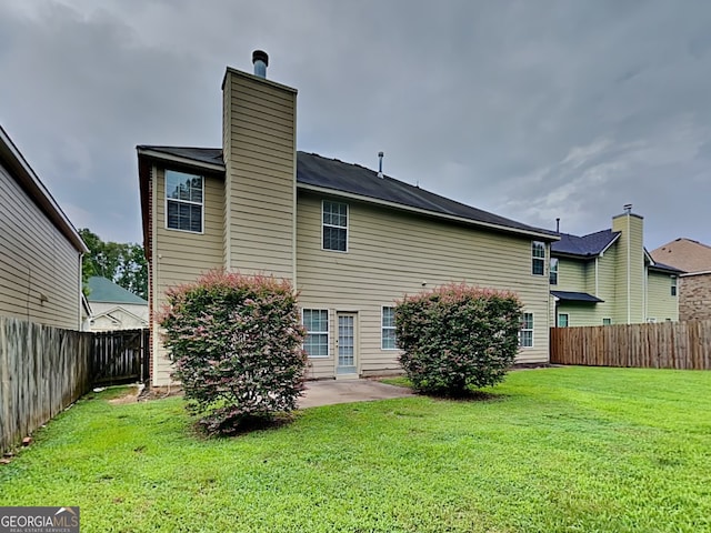 rear view of house with a yard and a patio area