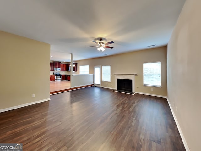 unfurnished living room with dark wood-type flooring and ceiling fan