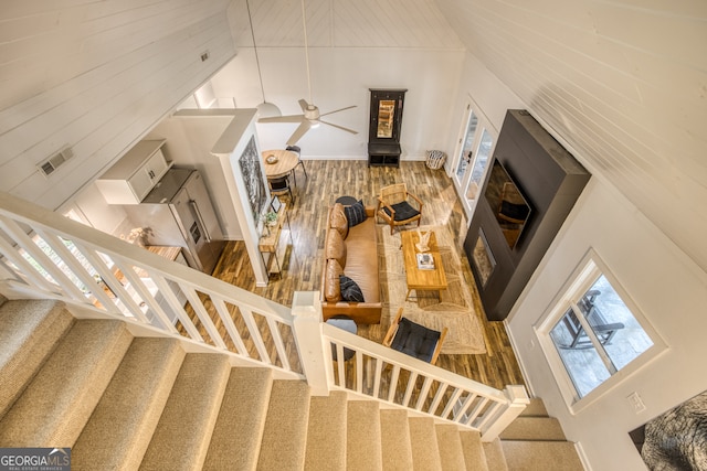 stairway featuring carpet flooring, ceiling fan, and high vaulted ceiling