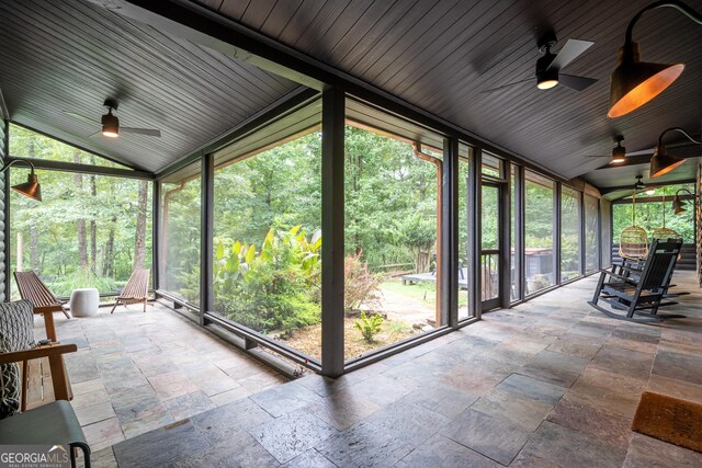 unfurnished sunroom with a wealth of natural light, ceiling fan, and vaulted ceiling