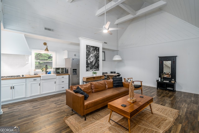 living room with beam ceiling, ceiling fan, dark hardwood / wood-style floors, sink, and high vaulted ceiling