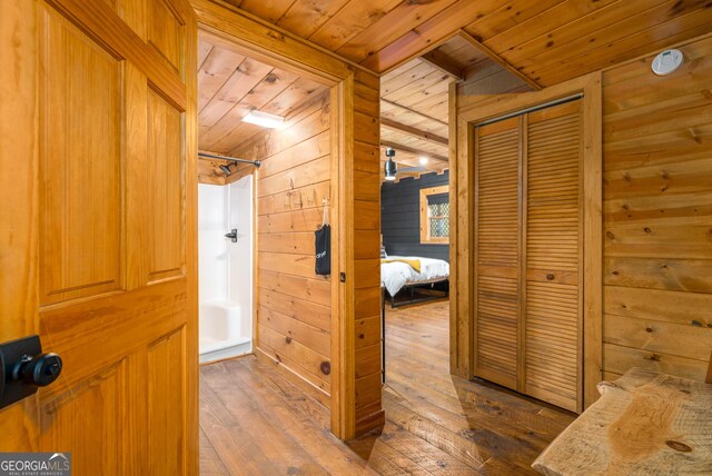 corridor with wood walls, hardwood / wood-style floors, and wood ceiling