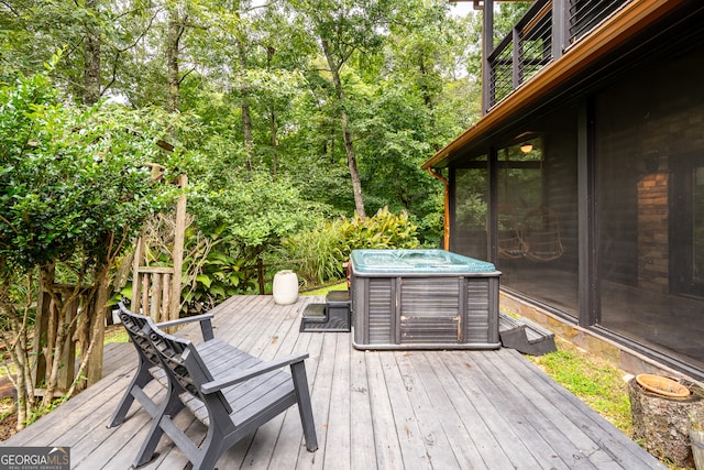 deck featuring a sunroom and a hot tub