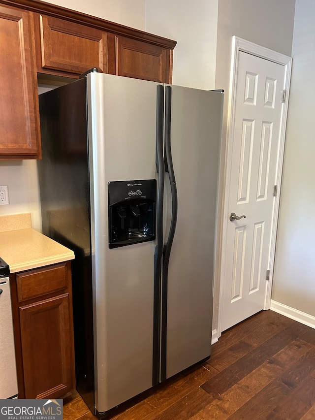 kitchen featuring stainless steel fridge and dark hardwood / wood-style flooring