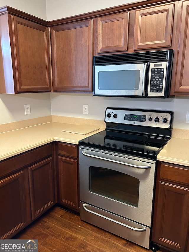 kitchen with stainless steel appliances and dark hardwood / wood-style flooring