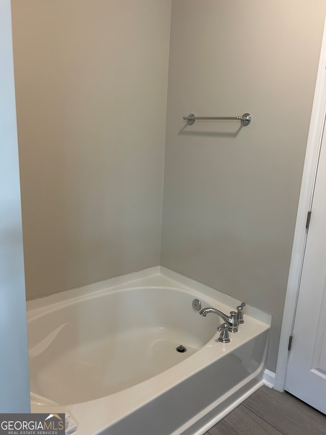 bathroom featuring wood-type flooring and a tub