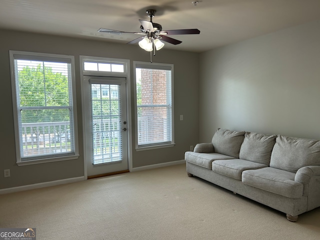 carpeted living room with ceiling fan