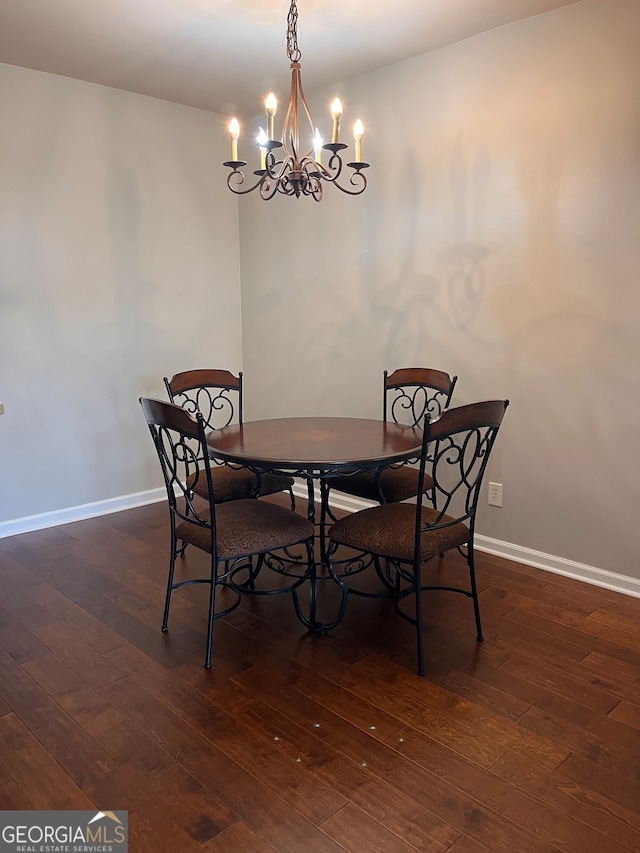 dining room with dark hardwood / wood-style flooring and an inviting chandelier