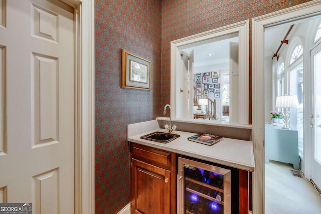 bar featuring sink, light carpet, and wine cooler