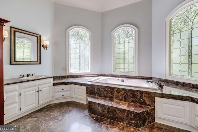 bathroom featuring vanity, tiled tub, and tile patterned flooring