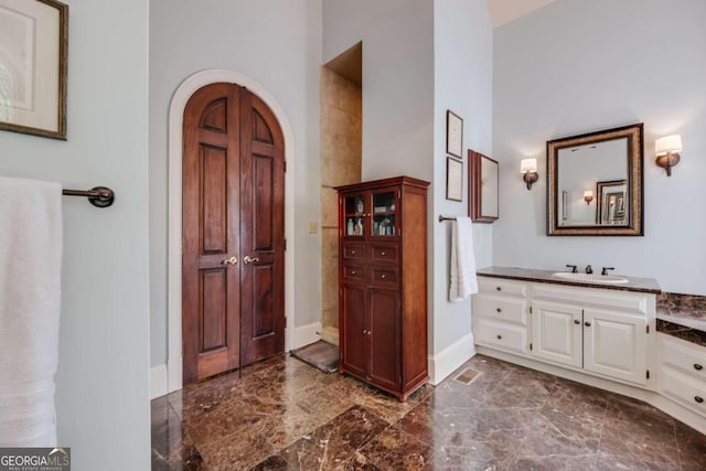 full bath with visible vents, baseboards, marble finish floor, a high ceiling, and vanity